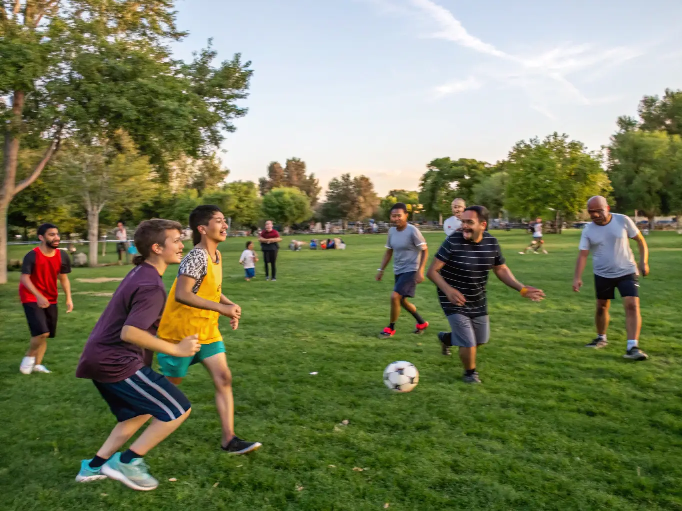 A photo of handball players participating in a community outreach event, teaching basic handball skills to children in a local park, emphasizing community engagement.